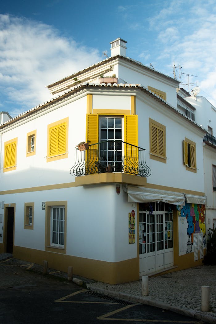 A picturesque corner building with yellow shutters in the old town of Lagos, Portugal.